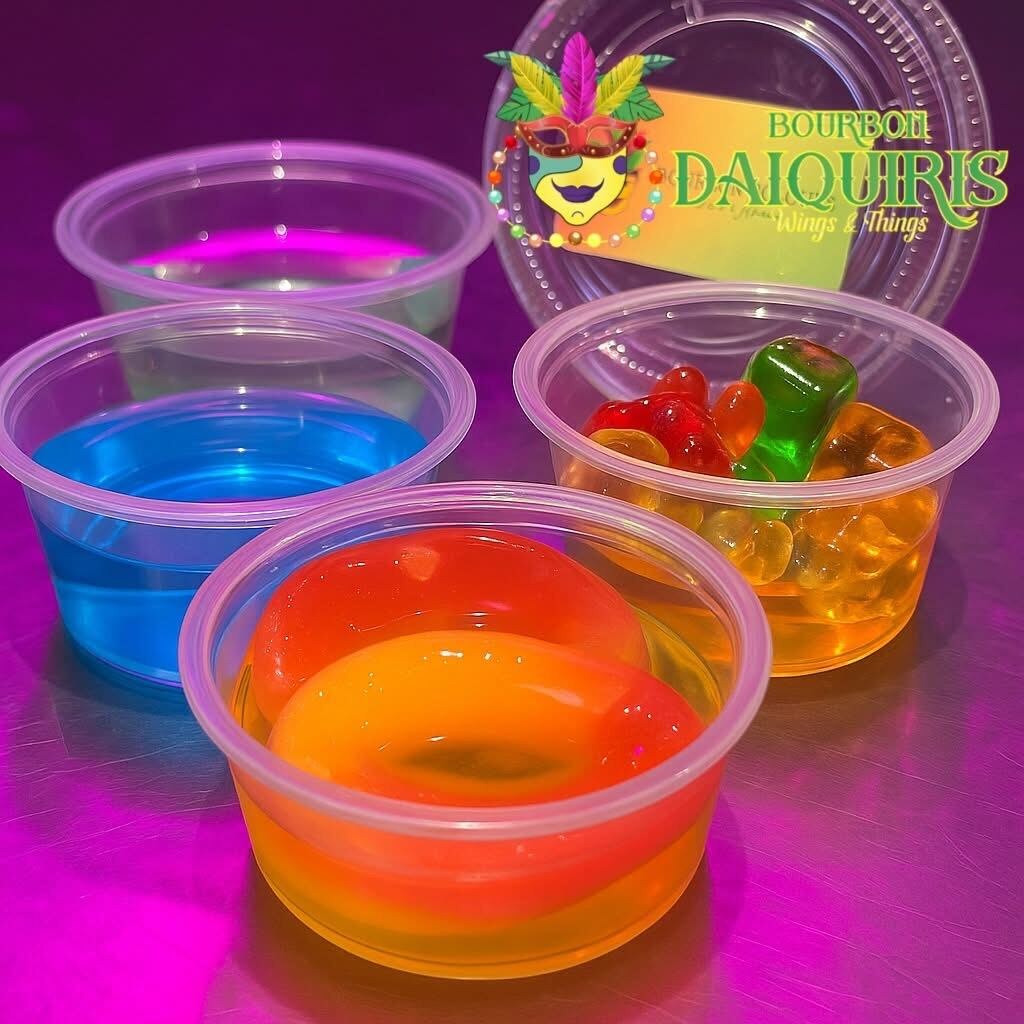 Four cups of jello shots, one topped with gummy bears
